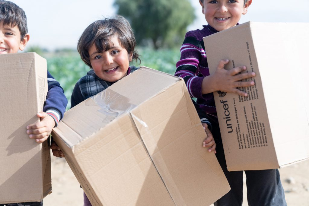 Children carrying unicef boxes