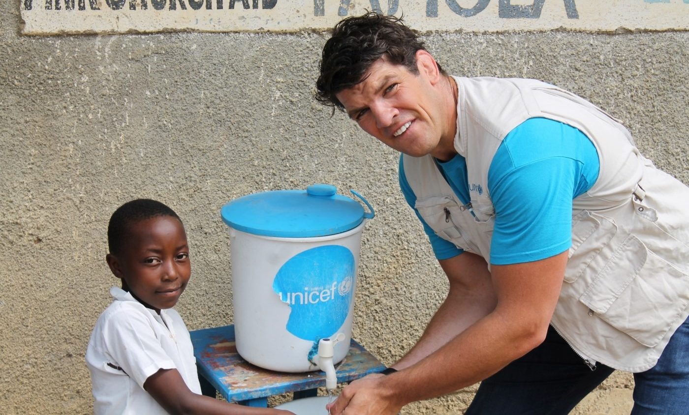 UNICEF Ambassador Donncha O'Callaghan shown Ebola prevention techniques by 8-year-old Malonga at a school in the DRC