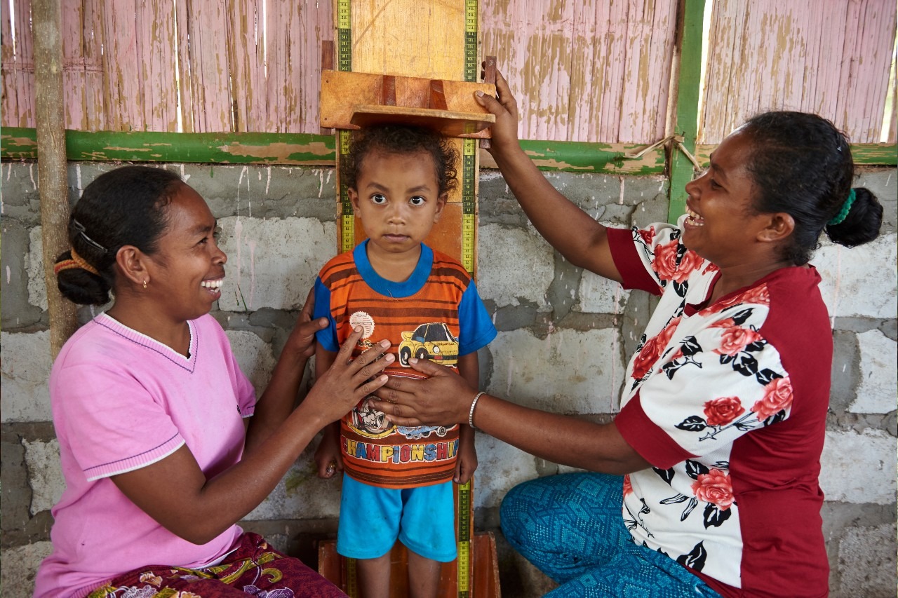 A health worker measures a child's height