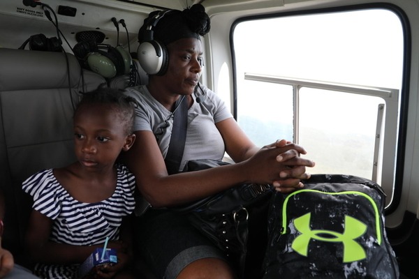 A young girl and her mother are sitting in a helicopter