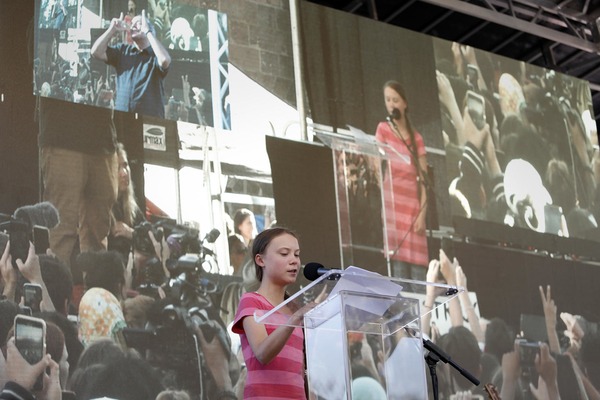 A teenage girl is giving a speech in front of thousands of people