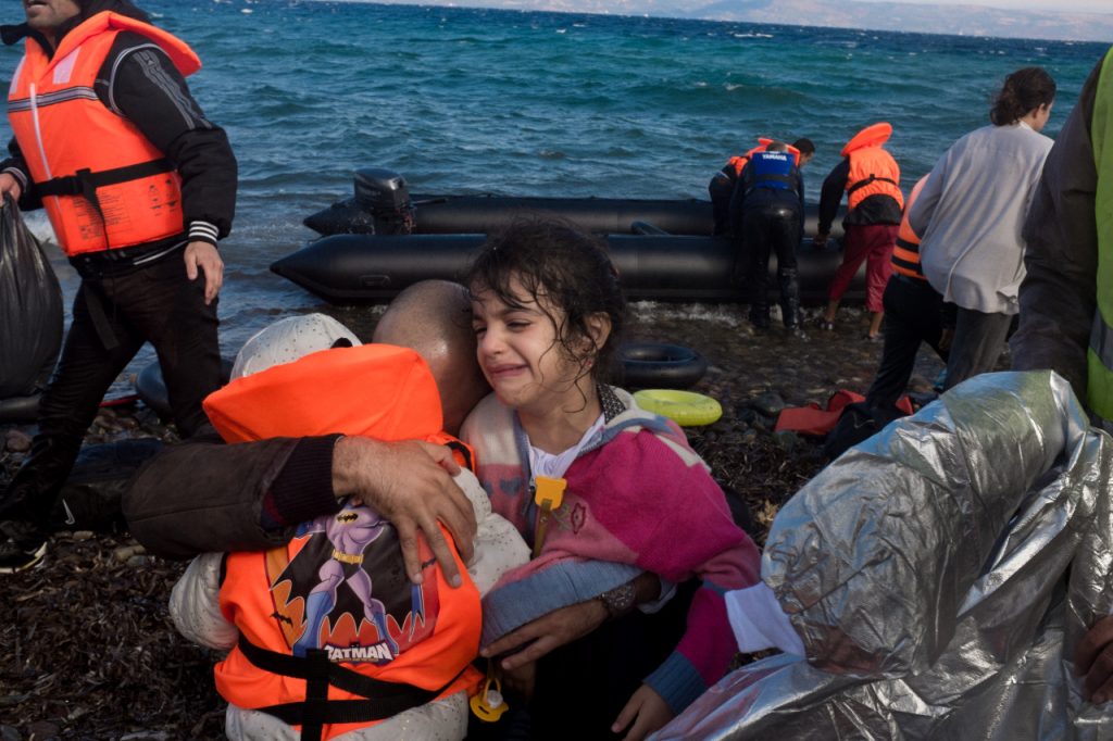 hugs his daughters –30-month-old Safia and 4-year-old Sidra (crying) upon reaching shore, near the village of Skala Eressos, on the island of Lesbos, in the North Aegean region