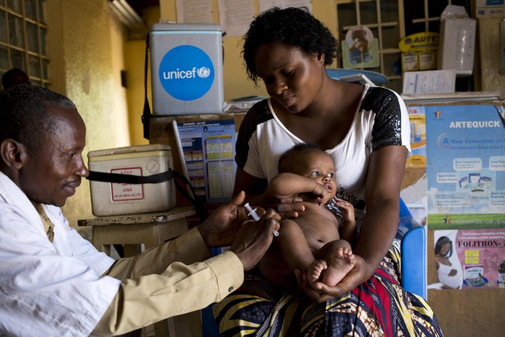 a doctor is vaccinating a baby held by his mother
