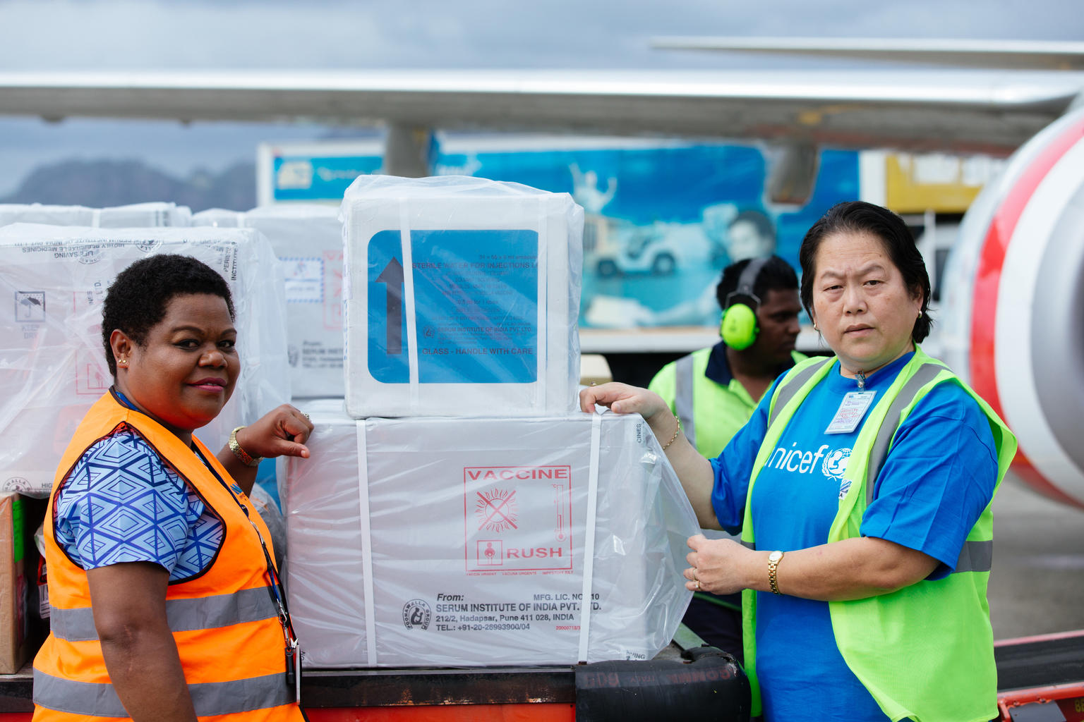 Two women are standing near medical supplies in an airport