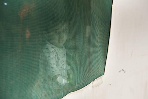 a boy is looking through a window 