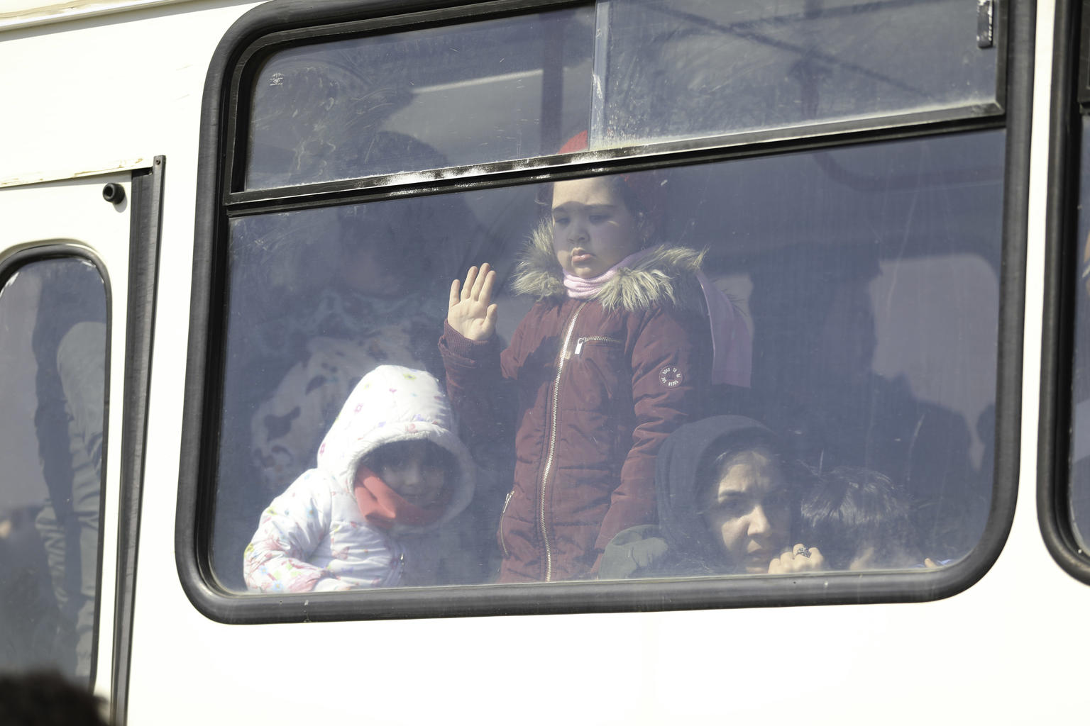 Child looking out from the window of a bus