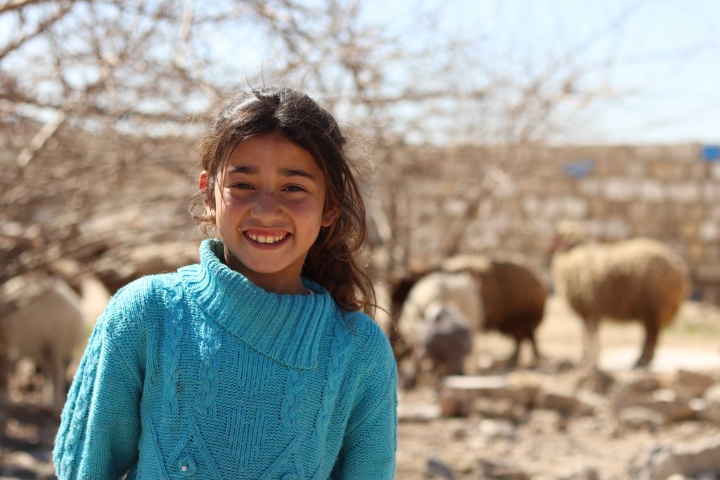 a girl stands in front of her family’s home