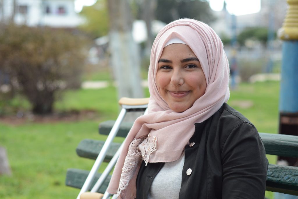 a girl is sitting on a bench