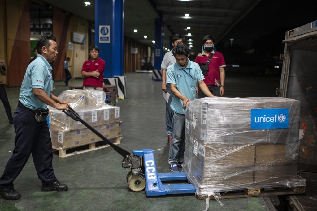 workers load medical aid equipment into trucks