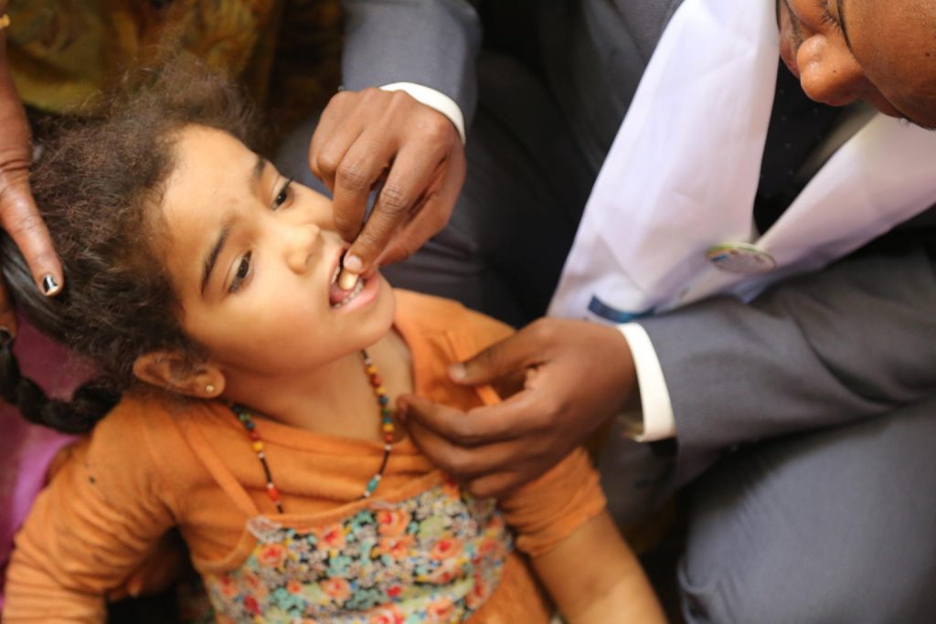 girl being given vitamin a supplement
