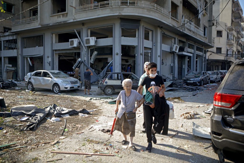 woman walking amongst rubble in beirut