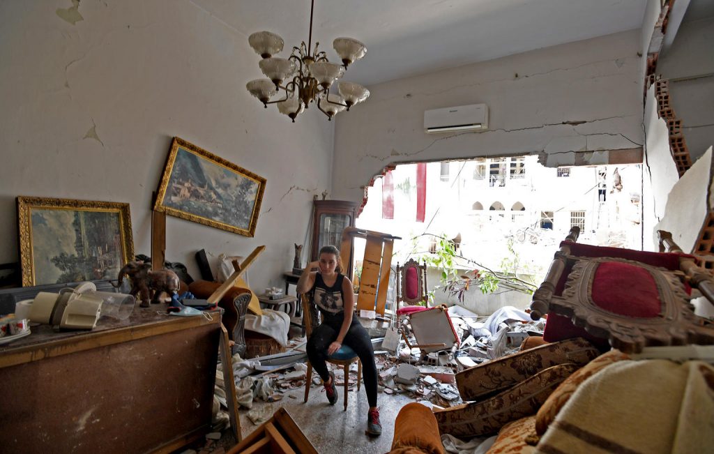woman sits in her destroyed apartment