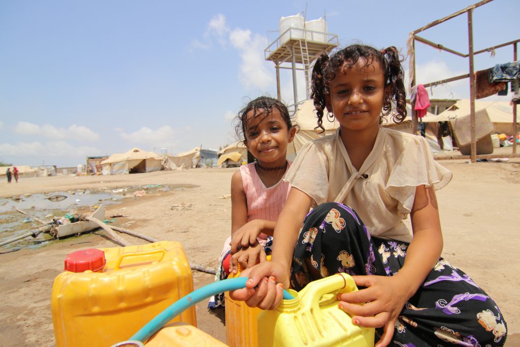 Yemeni child filling up water can