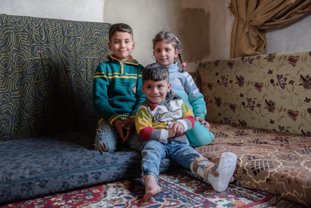 syrian siblings sit in their house