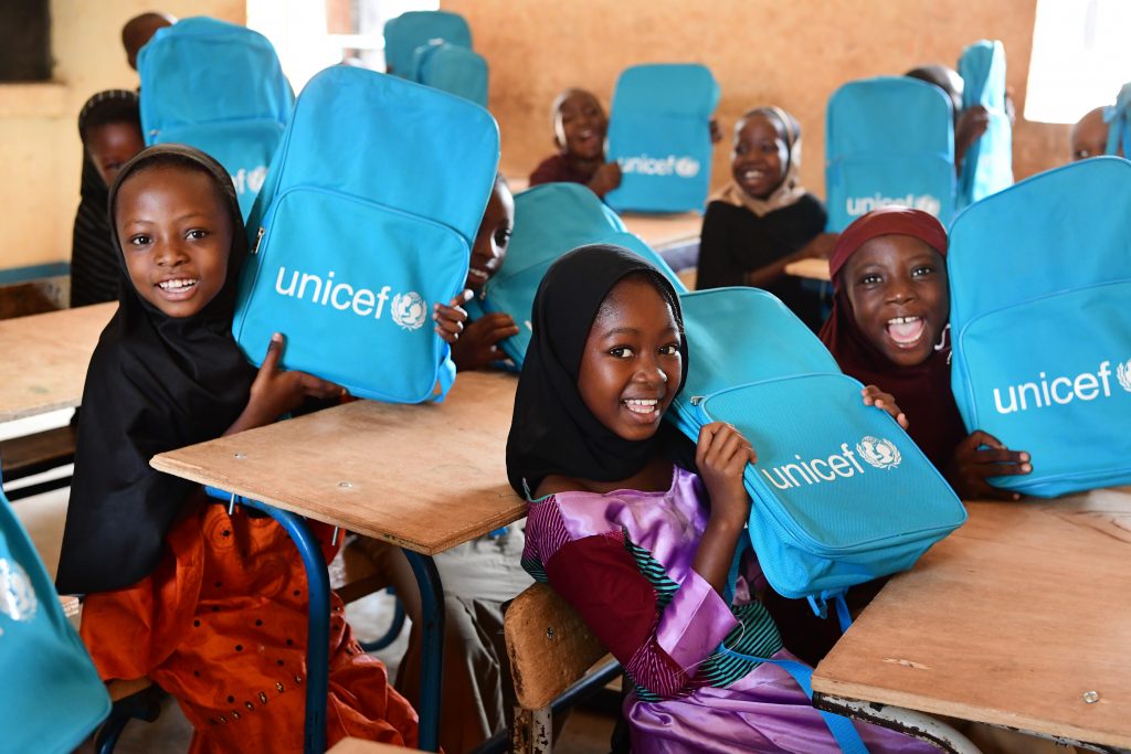 girls holding unicef school bags