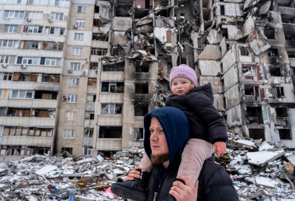 girl sits on father's shoulders