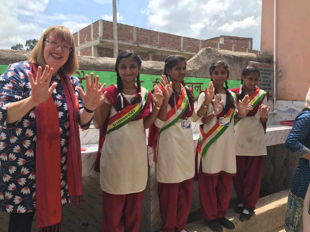 irish woman and indian girls smile for camera