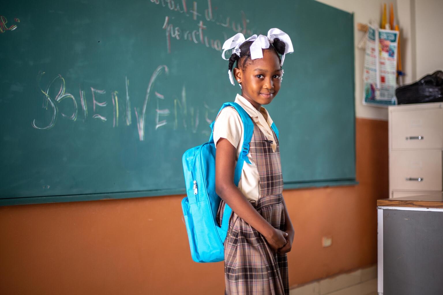 In Haiti, a student poses with a newly-received UNICEF backpack during a Back to School Ceremony at the School Saint-Anne in Les Cayes. 