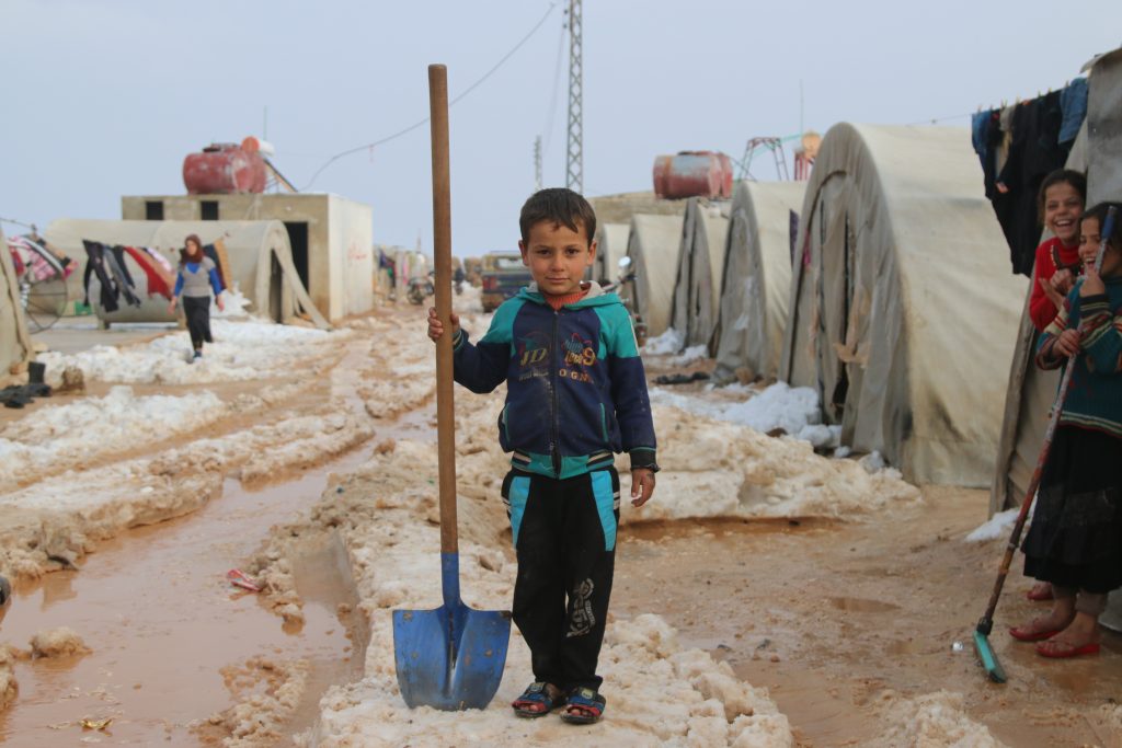Syrian boy holding shovel
