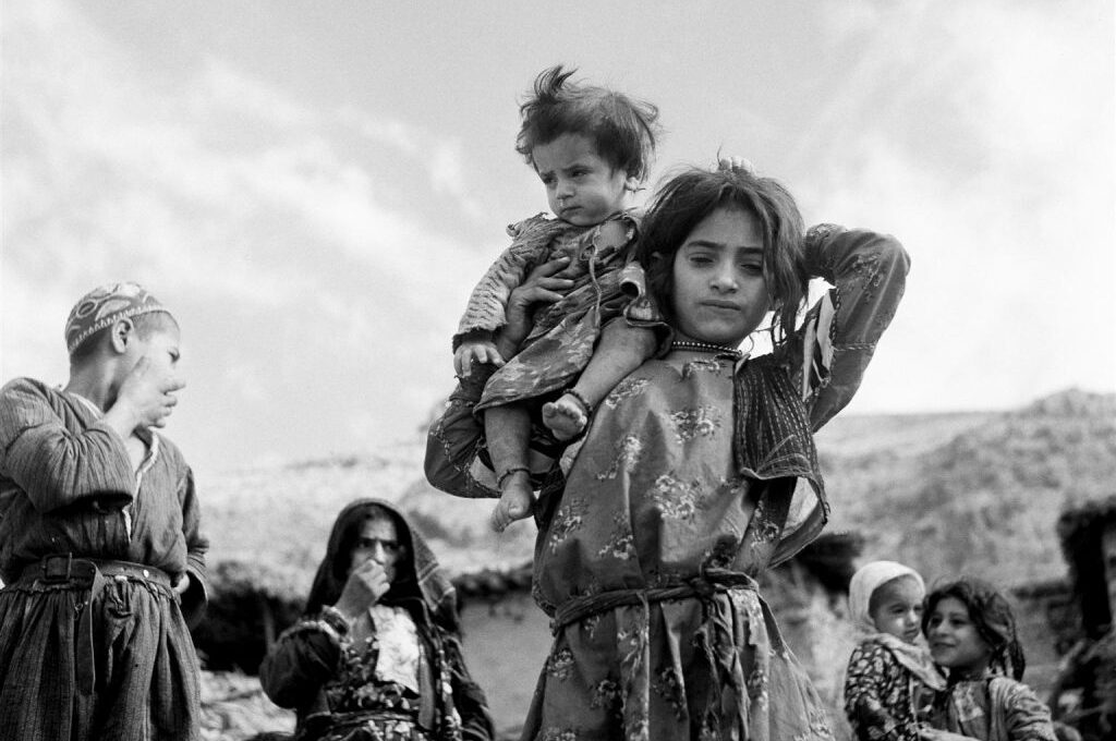 child carrying younger child on shoulder