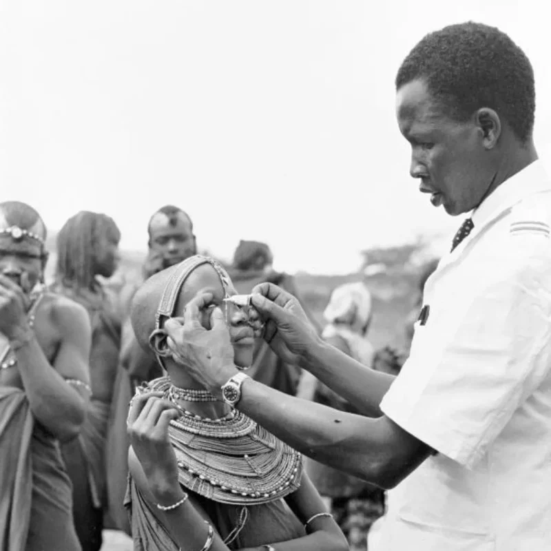 Kenya, 1950: A health worker from a UNICEF-assisted mobile health unit in Olobelibel applies antibiotic ointment to treat a child affected by trachoma.
