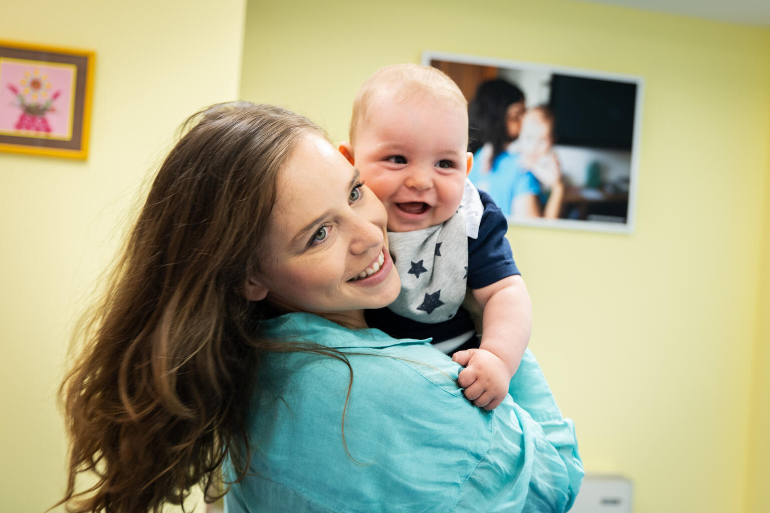 mother holds smiling baby - UNICEF's mission statement
