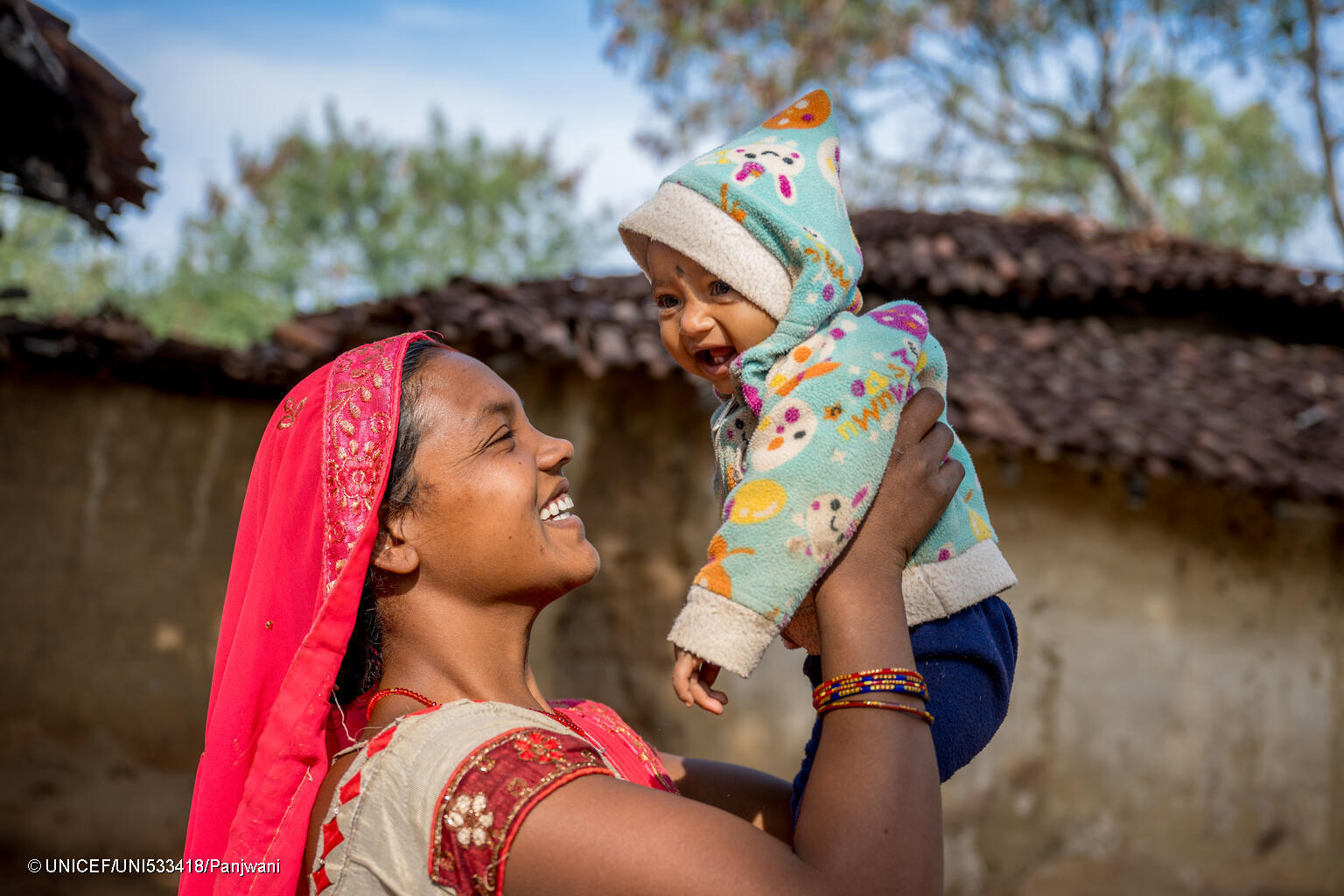 mother lifting child in arms
