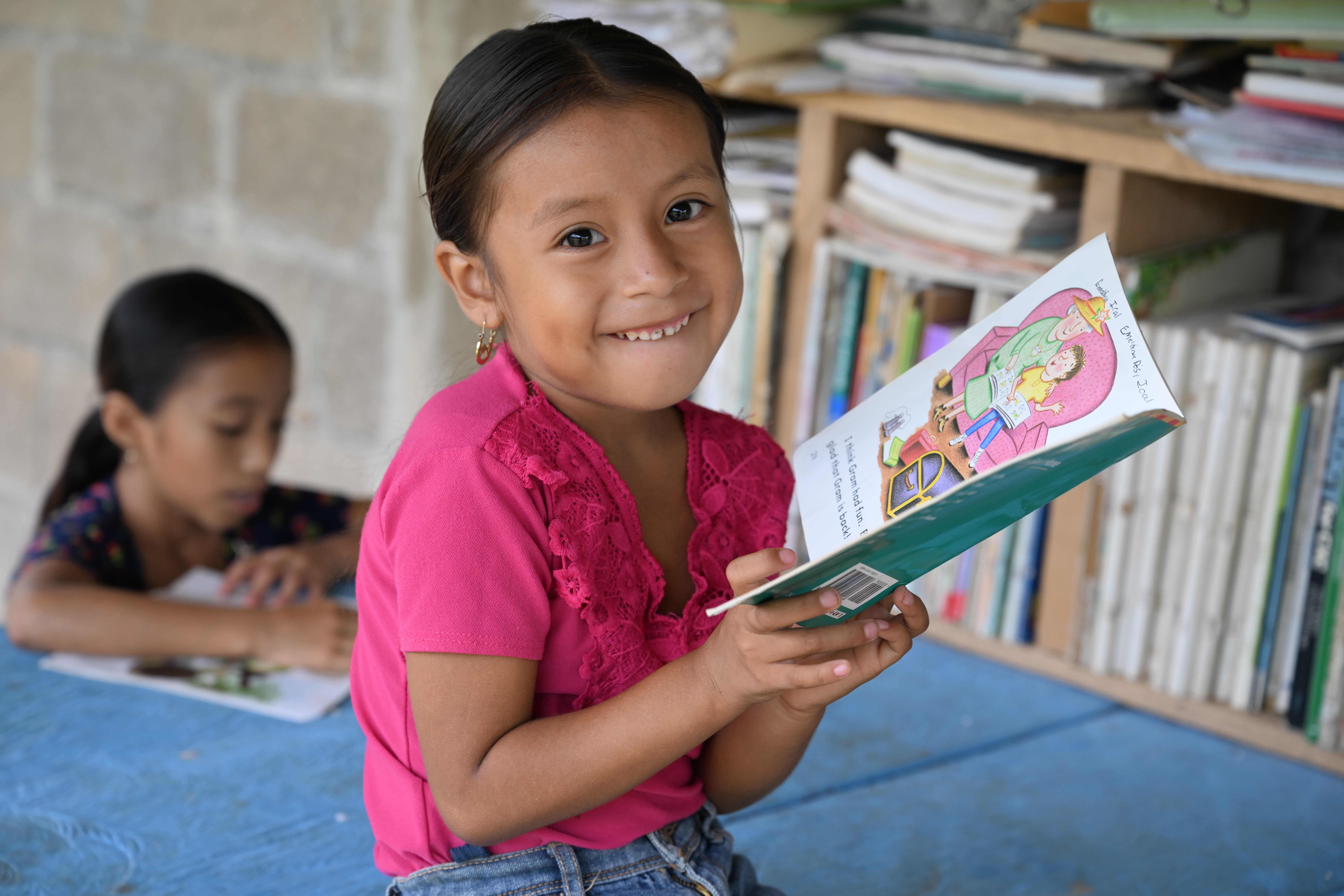 girl smiles while holding book