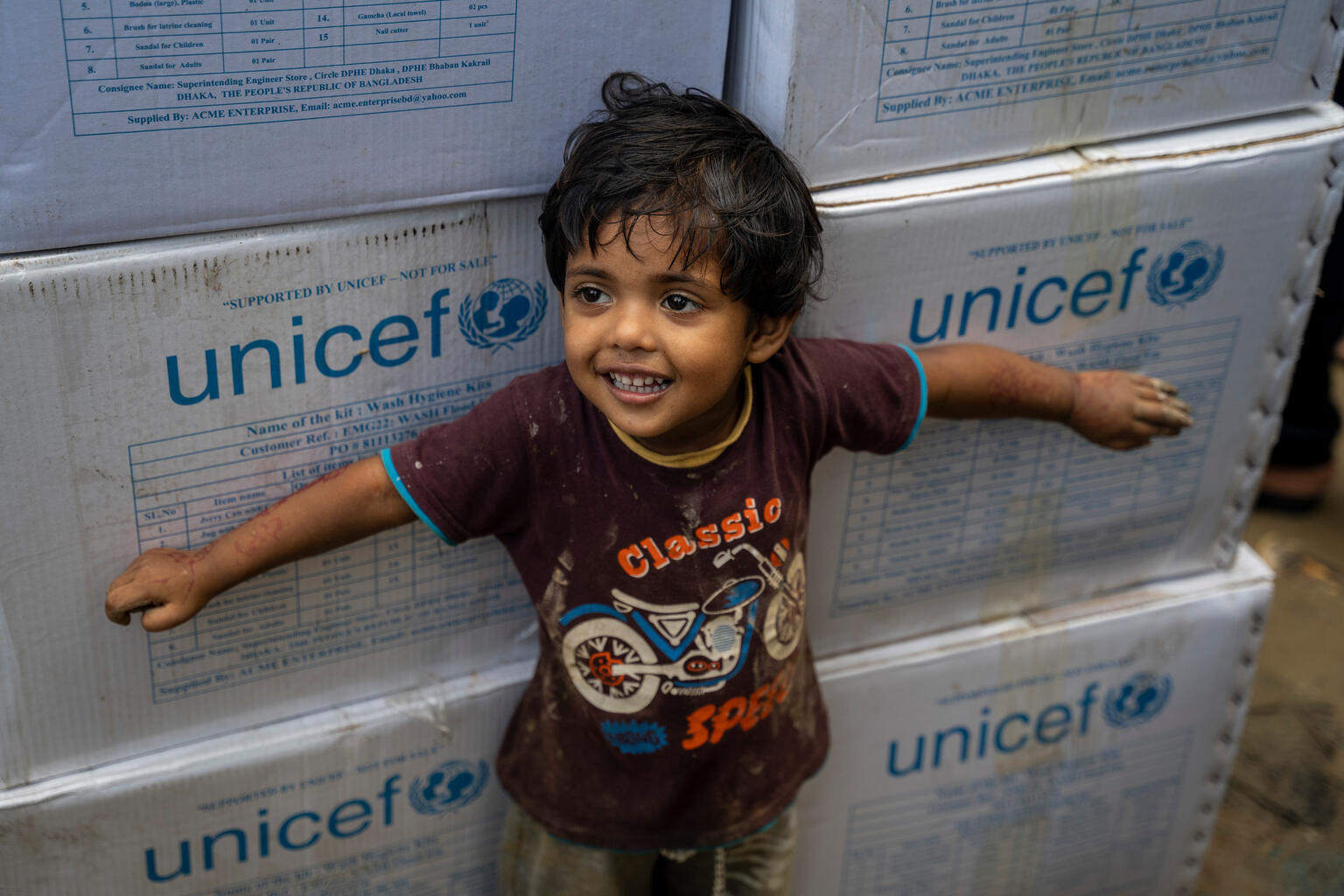 boy stands in front of unicef supplies