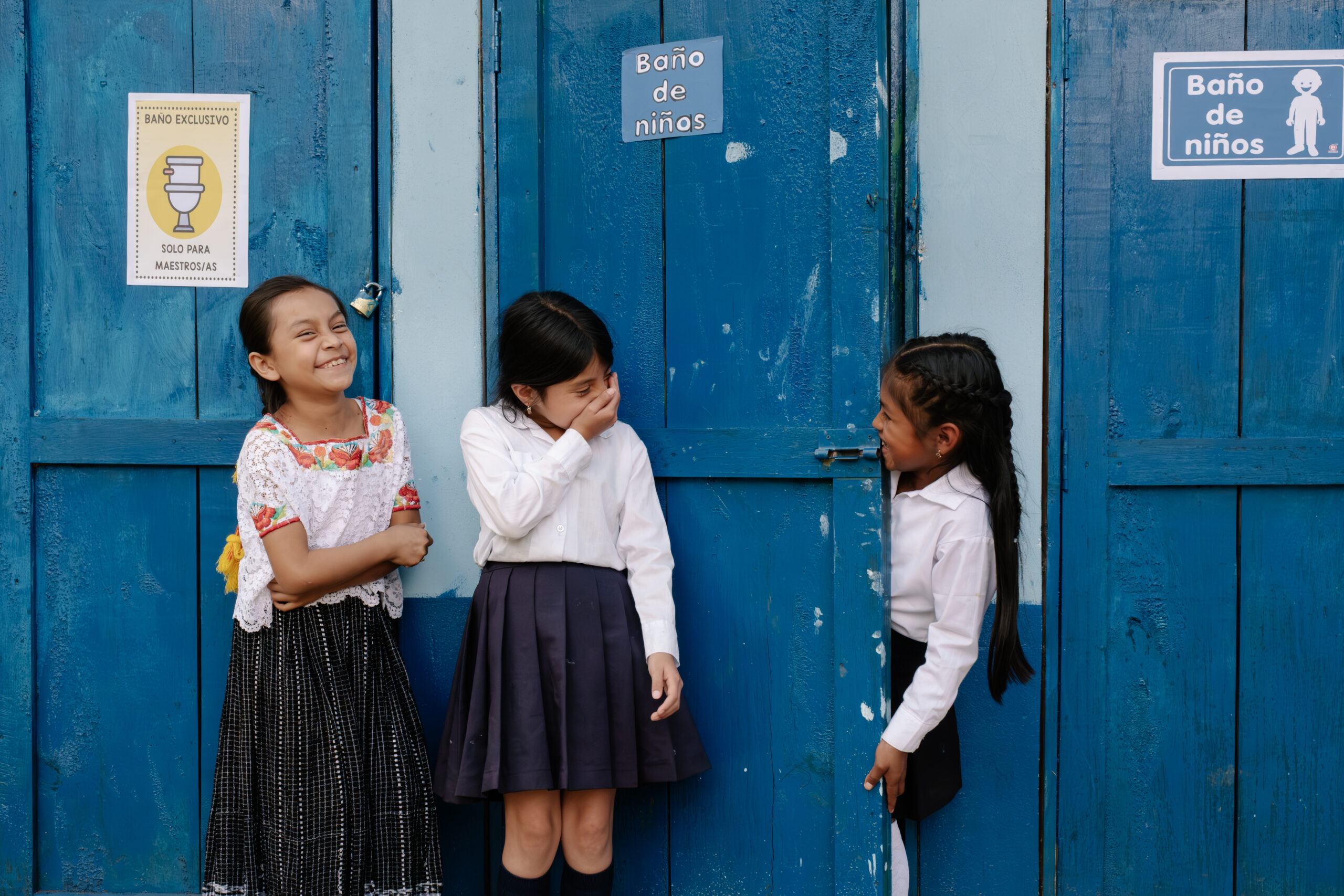 a group of girls laugh outside school toilets
