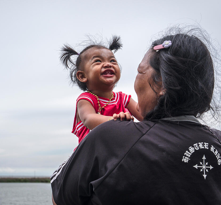 Child laughs in mother's arms