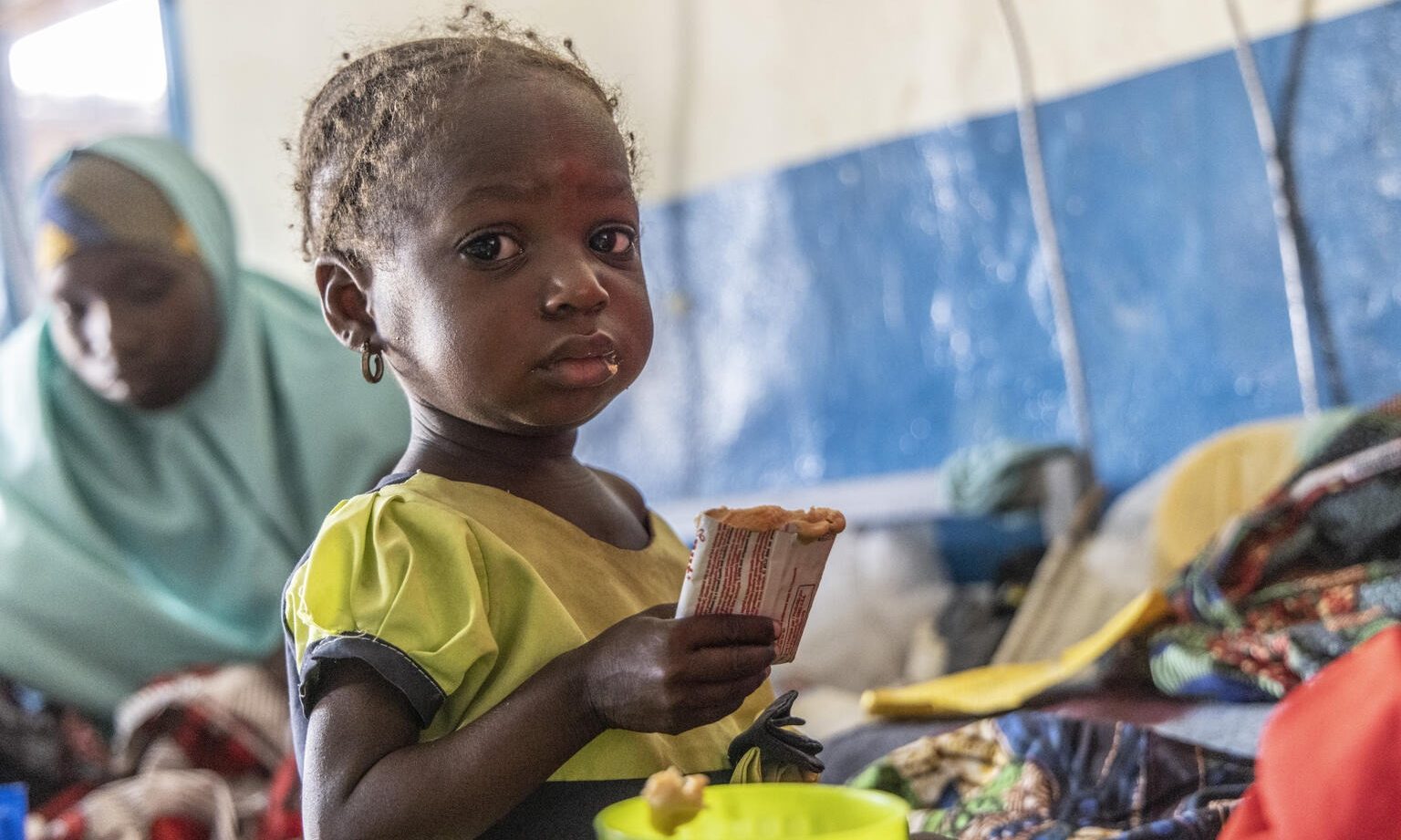 Amira eats from a sachet of ready-to-use therapeutic food.