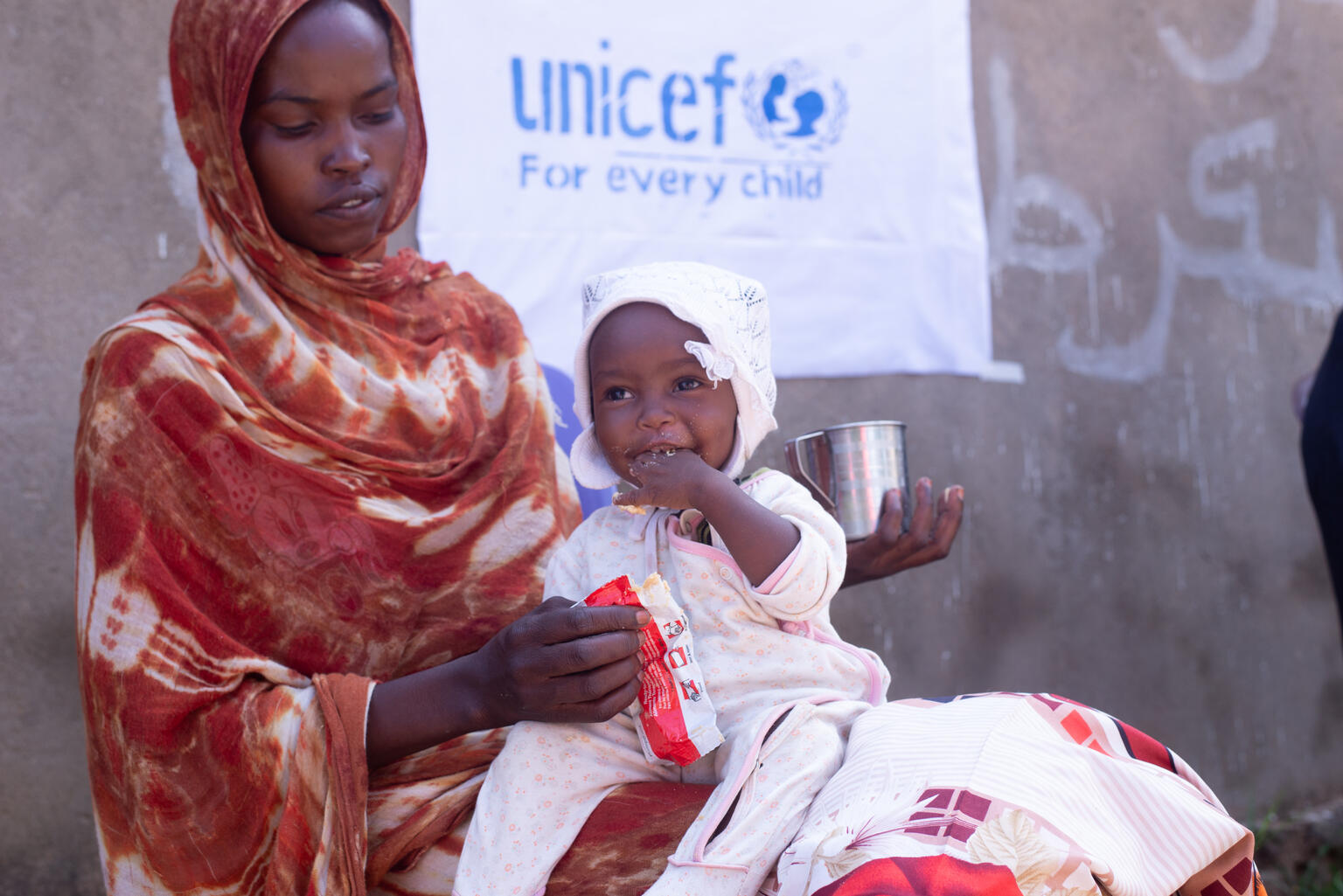 13-month-old Khadija enjoys her ready-to-use-therapeutic food in Central Darfur.