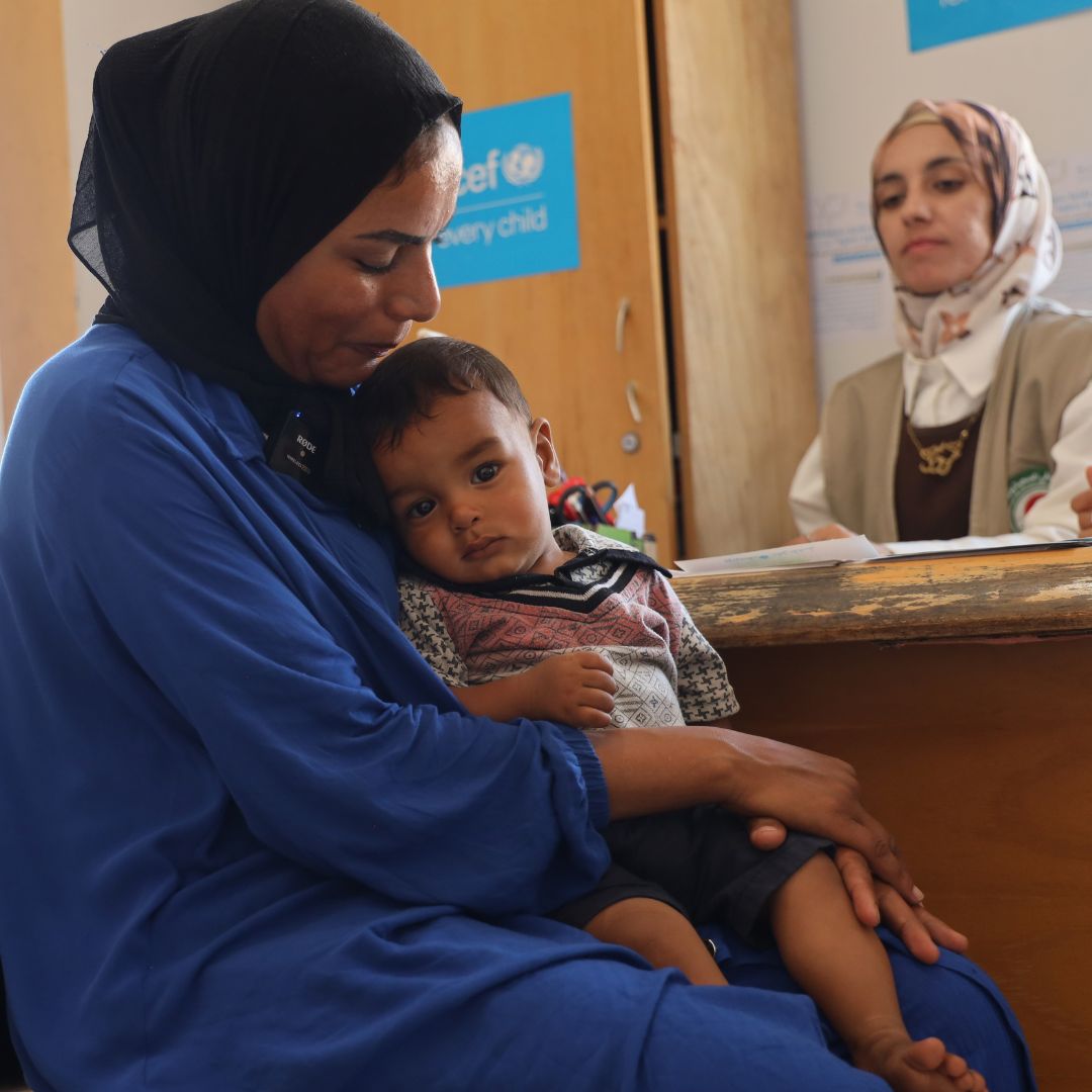 Monthly donations can help children like this boy held by his mother in a UNICEF clinic.