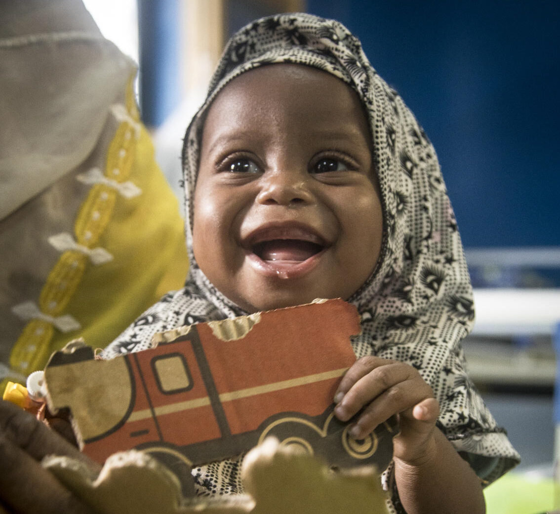A baby plays with a toy