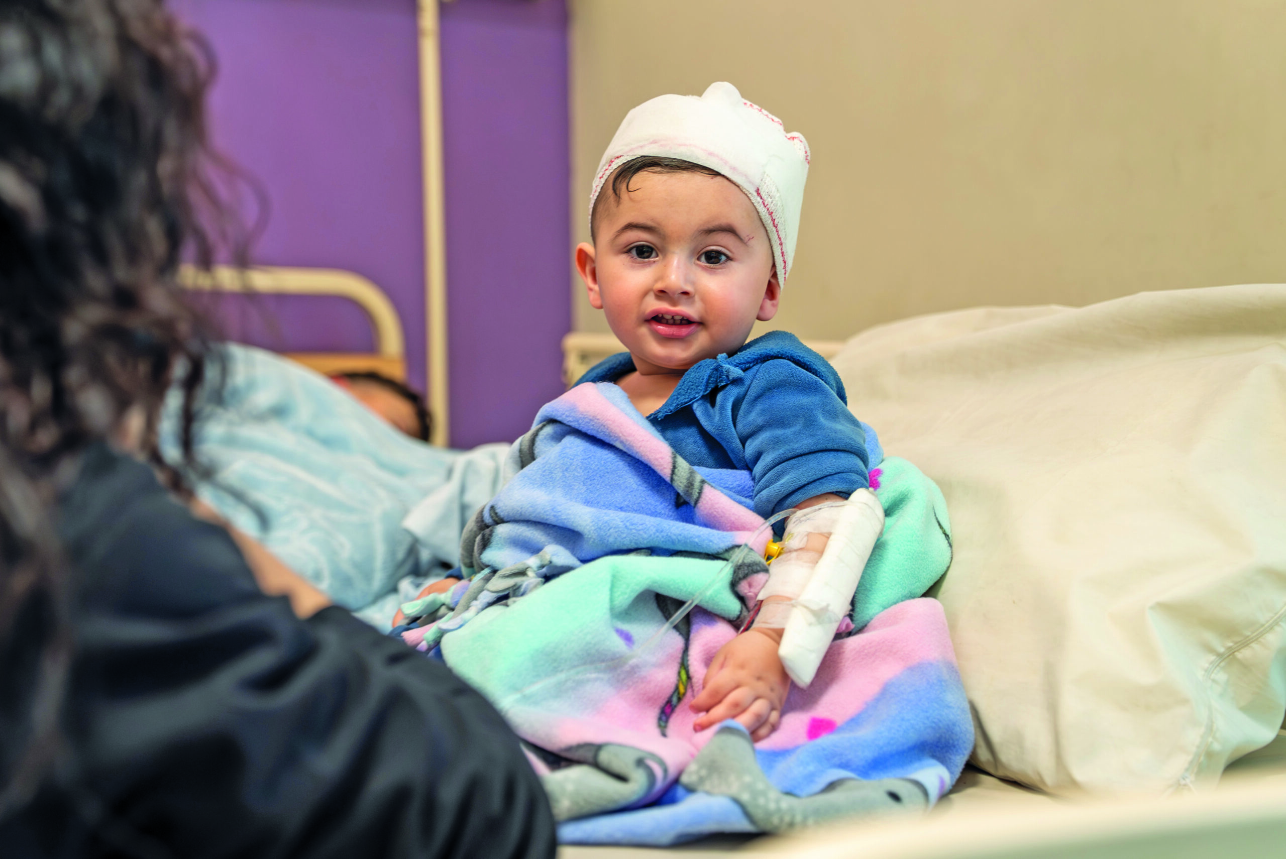 An injured boy in bed helped by donations