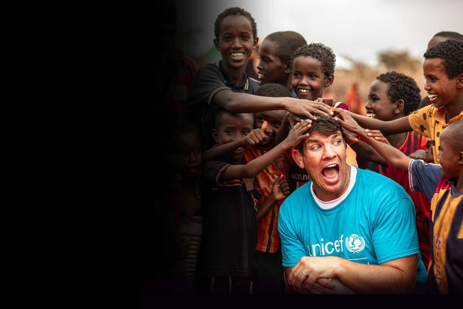 Donncha O'Callaghan, one of UNICEF's ambassadors, laughing with children.
