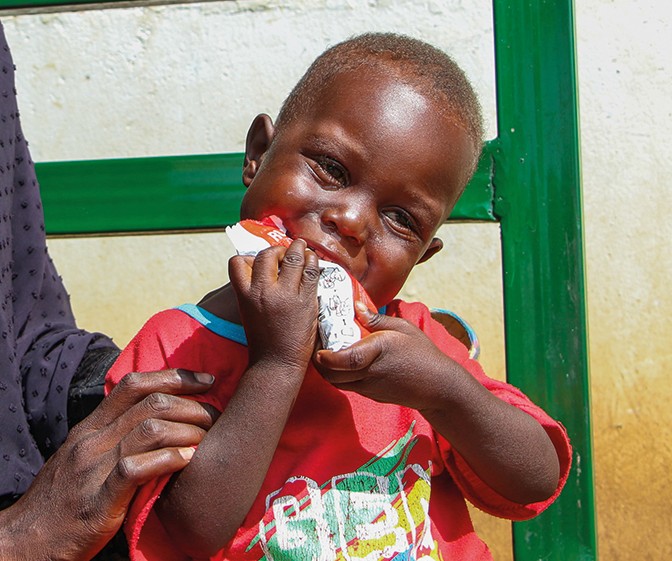 A child eats RUTF food in Sudan.