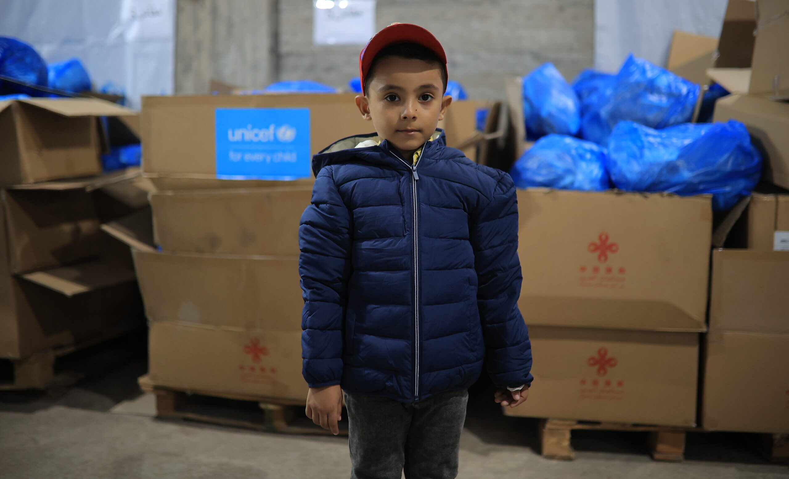 A child in Gaza in Palestine wearing a warm winter coat provided by those who donate to UNICEF.